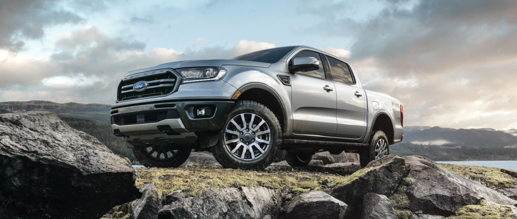 A silver 2022 Ford Ranger parked on top of rocks with a cloudy sky in the background.