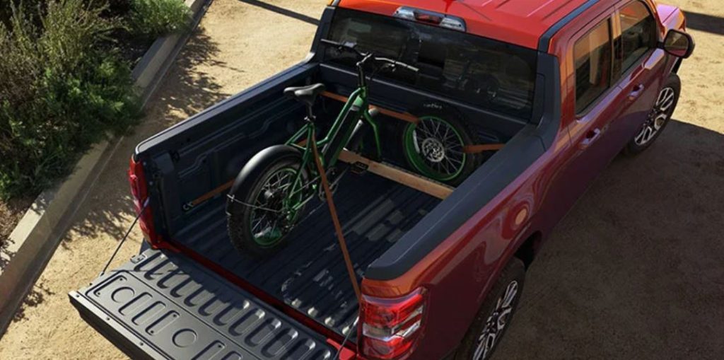 Overhead shot of a red 2023 Ford Maverick with a bike in the trunk bed.