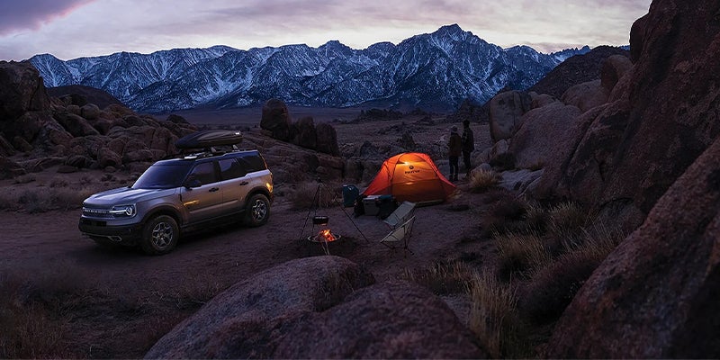 A sunset scene in the mountains featuring camping and a 2023 Ford Bronco Sport.