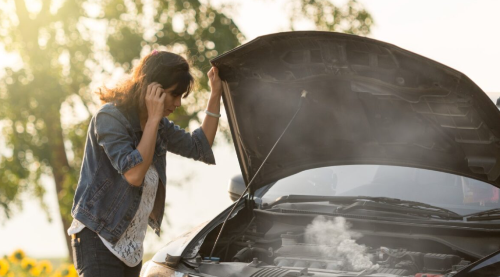 A woman checking out her over heating engine.